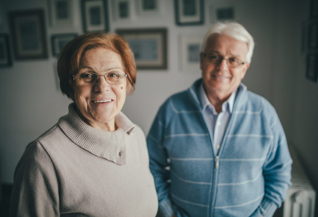 A photo of a senior woman and man in their house. The are in the 70s and enjoy life.