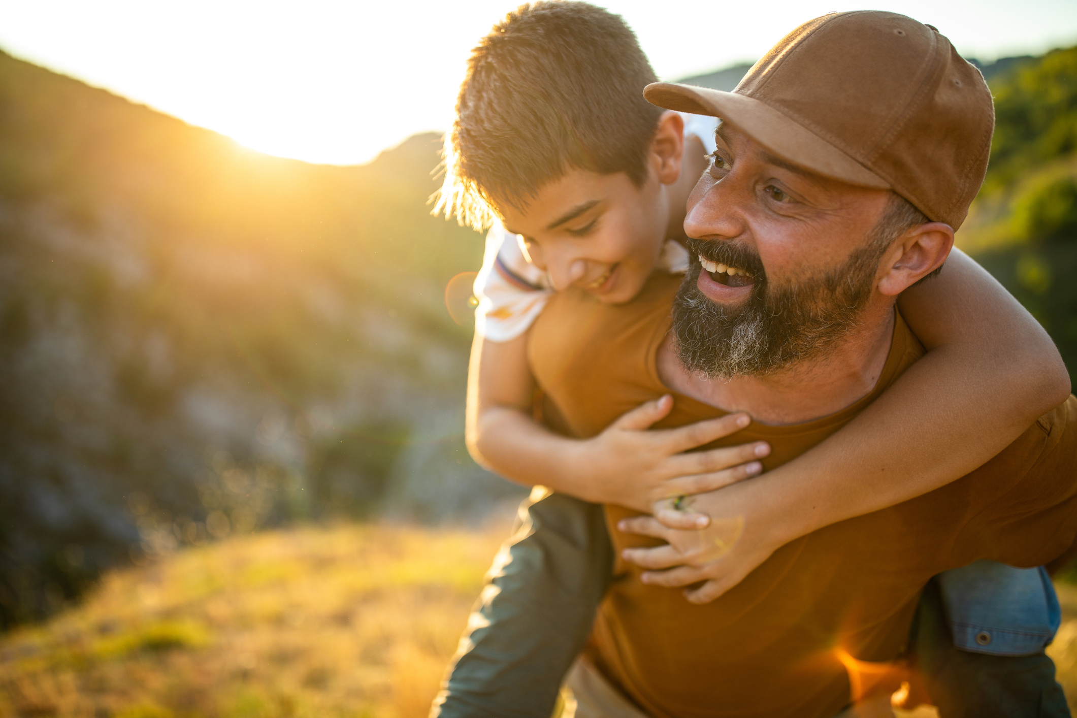 father carrying son on back
