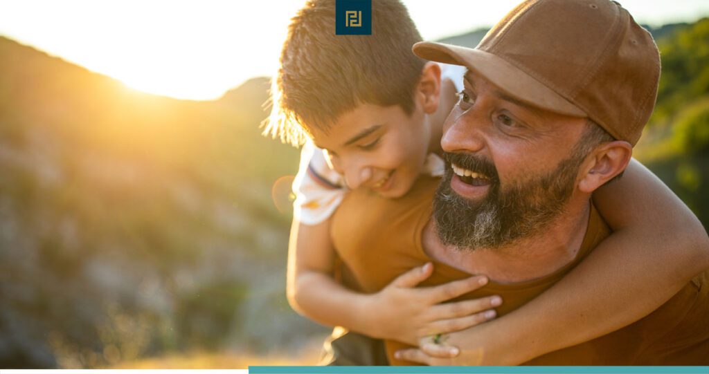 father with child on back outdoors