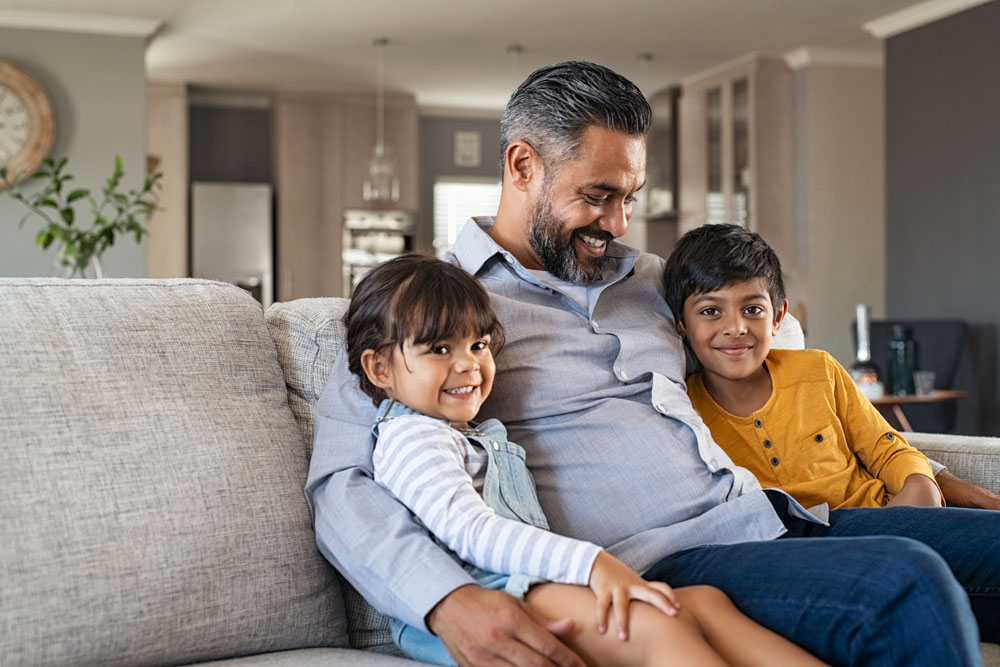 Father sitting with kids on couch