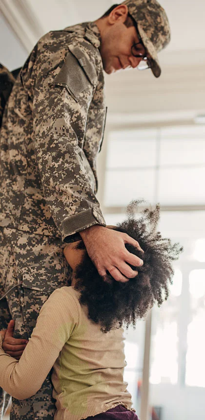 father in military uniform looking at daughter