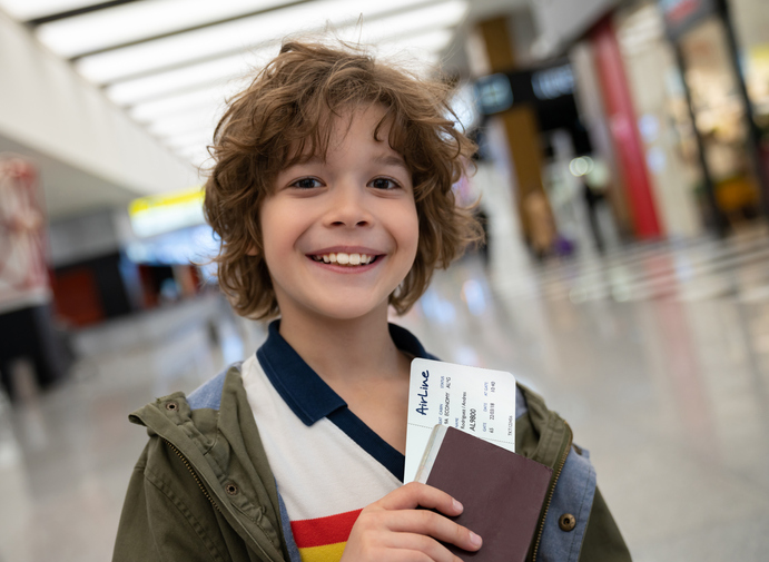 Child with passport in airport hallway