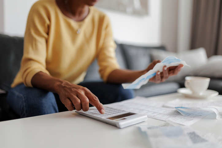 A person reviewing paper and calculating costs to set budget