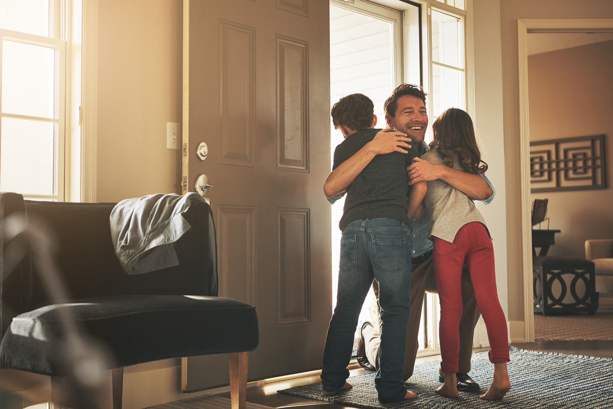 A father hugging his two children, representing Colorado's approach to fathers' rights and answering the question 'Is Colorado a fathers' rights state?'