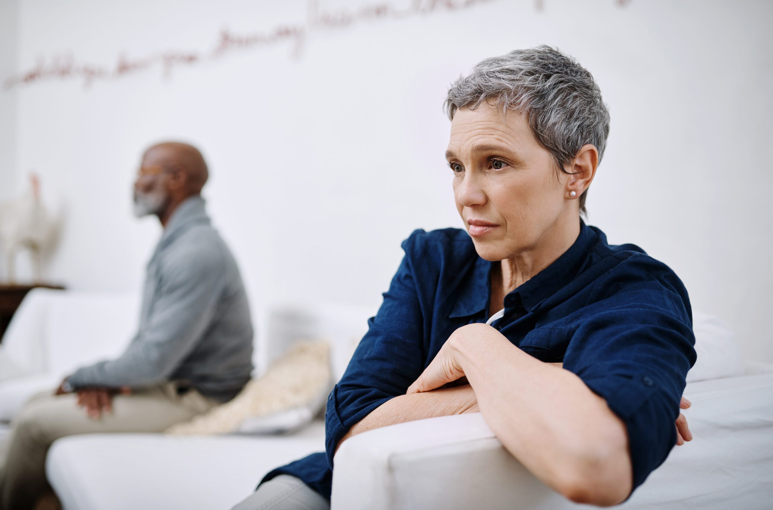 Shot of an unhappy senior couple sitting separately on a couch after having an argument at home